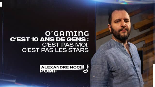 Homme en chemise bleue devant fond sombre.