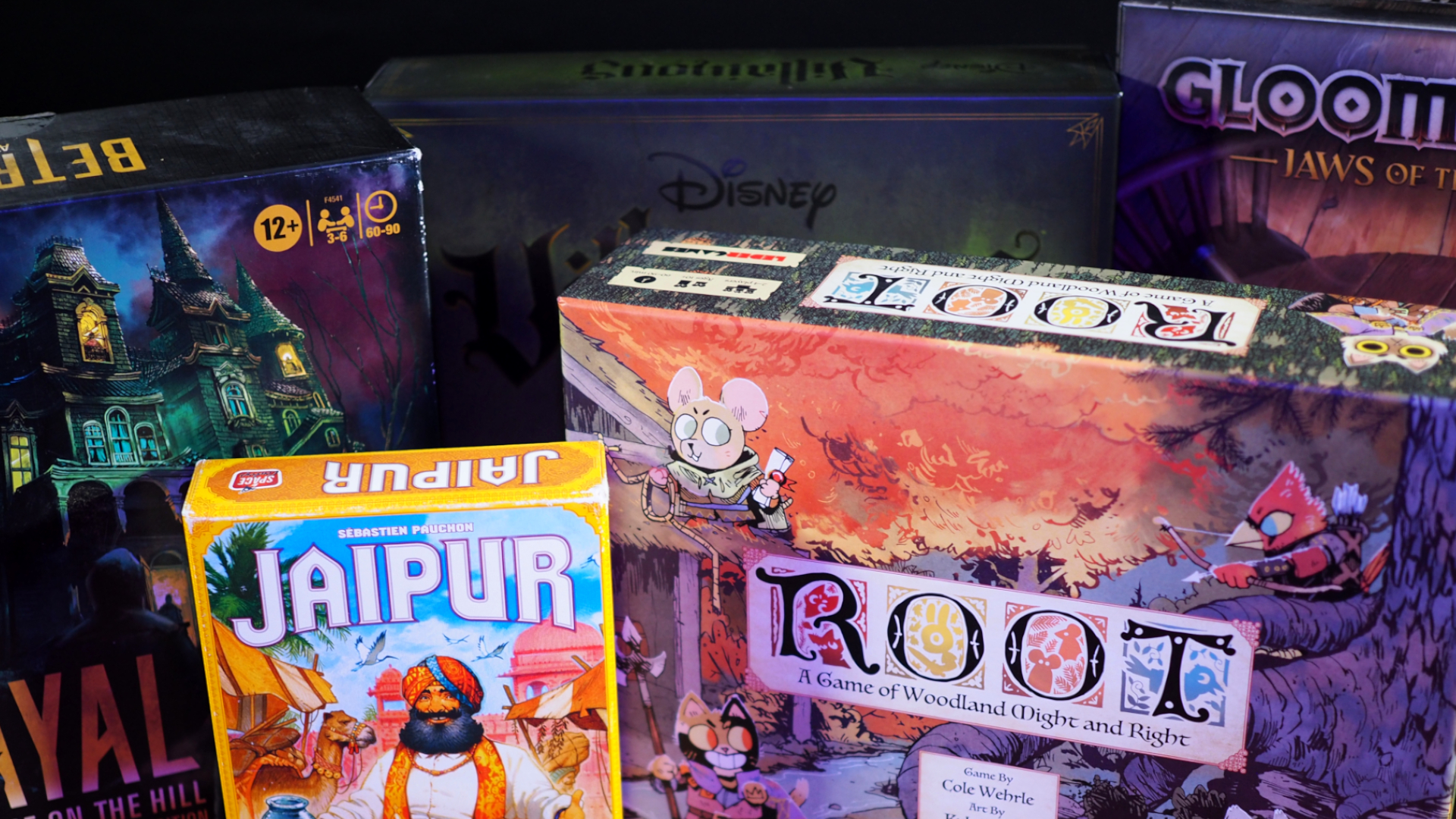 Une collection de boîtes de jeux de société debout sur un fond sombre