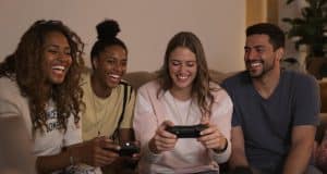 Friends laughing and playing video games together