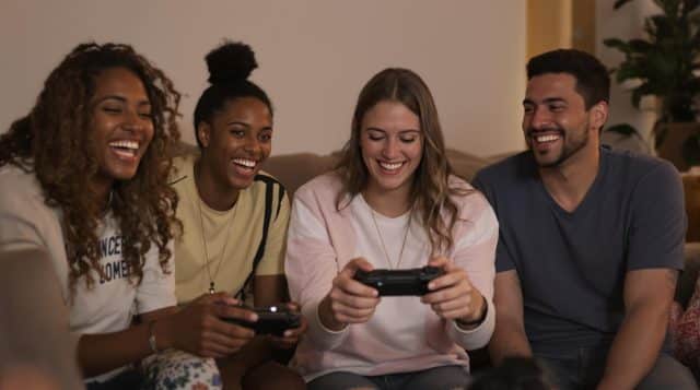 Friends laughing and playing video games together