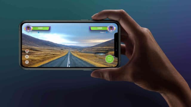 le jeu de géographie le plus captivant s'invite au festival Personne jouant à un jeu de conduite sur mobile.