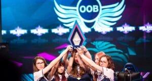 Équipe féminine levant un trophée sur scène.