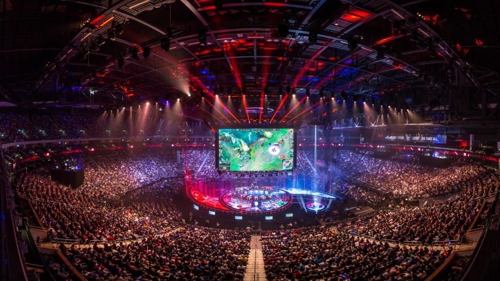 Compétition e-sport dans un stade rempli de spectateurs.