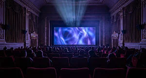 Spectateurs dans un cinéma regardant un écran lumineux.