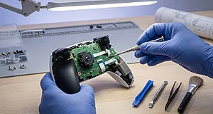 Réparation d'une manette de jeu électronique, outils présents.