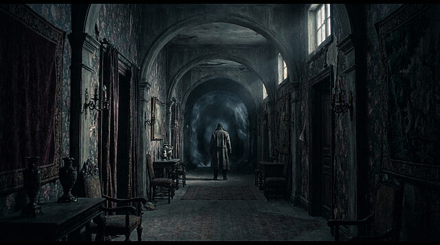 Layers of Fear 3 : Le Couloir du Cauchemar Image sombre d'un couloir ancien et délabré. Un personnage en manteau se tient dos à nous, face à un portail sombre et mystérieux.