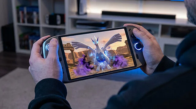 Lugia en action : Pokémon XD imaginé sur Switch 2 Un joueur tient une console portable affichant Lugia de Pokémon XD au milieu d'un combat dans un décor désertique.