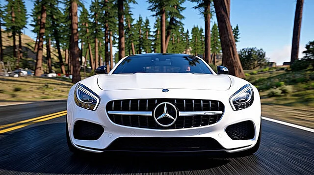 Mercedes-Benz AMG GT : Luxe et vitesse virtuelle Vue frontale d'une Mercedes-Benz AMG GT blanche sur une route asphaltée, bordée de grands arbres. Le ciel est bleu.