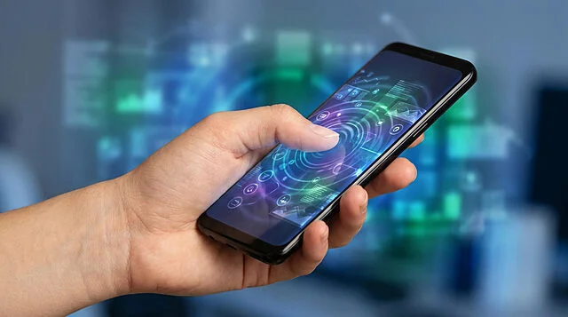 Aperçu de One UI 9 sur Galaxy S26 Une main tenant un smartphone affichant une interface utilisateur futuriste et holographique aux tons bleus et verts.
