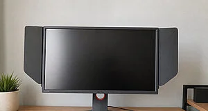 Moniteur gaming BenQ Zowie avec pare-soleil latéraux posé sur un bureau en bois.
