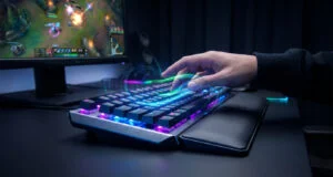 Main d'un joueur interagissant avec un clavier mécanique RGB rétroéclairé avec des effets visuels dynamiques.