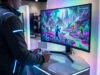 Splatoon Raiders : testez la démo sur Nintendo Switch 2 Joueur testant un jeu vidéo aux couleurs vives avec une manette dans un salon professionnel éclairé par des néons.