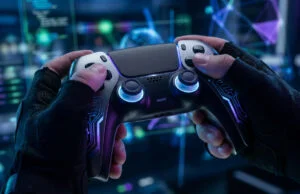 Mains portant des gants techniques tenant une manette futuriste devant un écran rempli de données numériques.