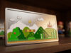 Plaque métallique gravée représentant un niveau classique de Super Mario World avec un château et des tuyaux verts.