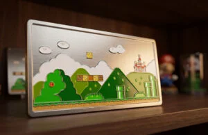 Plaque métallique gravée représentant un niveau classique de Super Mario World avec un château et des tuyaux verts.