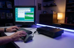 Mains jouant au Solitaire Windows 95 sur un écran CRT relié à une console PlayStation 2 posée sur un bureau.