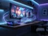 PC de jeu compact sur un bureau avec un écran incurvé affichant un paysage spatial sous un éclairage LED bleu néon.