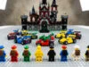 Huit figurines LEGO et des karts miniatures alignés sur une plaque de base devant un grand château en briques LEGO.