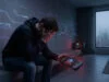 Aliens: Fireteam Elite injouable : fin du cloud sur Switch Un homme déçu tenant une console portable affichant une icône de cloud barrée dans une pièce moderne et sombre.