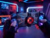 Meilleurs accessoires smartphone gaming 2026 : jouez comme un pro Mains tenant un smartphone avec manette intégrée et ventilateur de refroidissement dans une salle gaming néon.