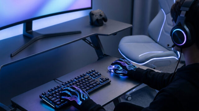 Setup gaming futuriste avec gants haptiques Un joueur portant des gants lumineux utilise un clavier et une souris dans un setup gaming moderne avec éclairage néon.
