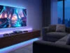 Accessoires Steam Machine 2026 : optimisez votre setup salon Setup gaming moderne avec TV murale, console Steam Machine, manettes et éclairage LED bleu dans un salon confortable.