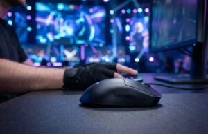 Logitech G Pro X Superlight 3 : faut-il craquer pour l’esport ? Gros plan sur une souris gaming Logitech G Pro X Superlight 3 posée sur un tapis, avec un joueur en arrière-plan.