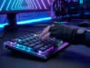 Une main gantée utilisant un clavier gaming mécanique avec éclairage RGB dans un setup PC futuriste.