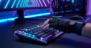 Une main gantée utilisant un clavier gaming mécanique avec éclairage RGB dans un setup PC futuriste.