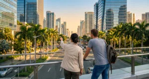 Deux personnes observent une ville moderne depuis une passerelle piétonne en surplomb d'une avenue.