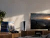 Sony arrête les jeux PS5 sur disque dès janvier 2028 Une console PS5 et une pile de jeux physiques posées sur un meuble TV avec un écran affichant un paysage.