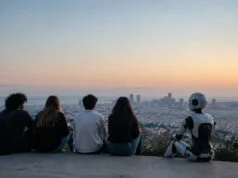 La génération Z et l’IA : usages massifs, craintes tenaces Quatre jeunes et un robot assis côte à côte, observant une ville au coucher du soleil.