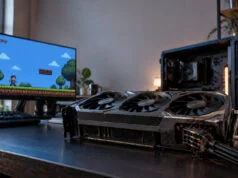 Une RTX 5090 fondue en jouant au pixel art, garantie refusée Carte graphique RTX 5090 gravement brûlée au niveau du connecteur d'alimentation posée sur un bureau devant un écran.