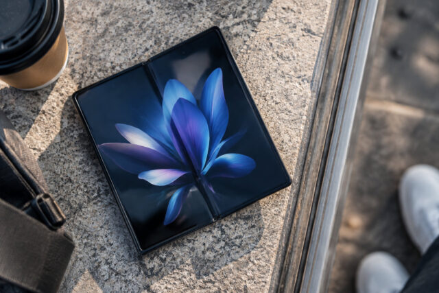 Samsung Galaxy Z Fold 8 : Vers un prix plus abordable ? Un smartphone pliant Samsung Galaxy Z Fold ouvert posé sur une surface en pierre avec un café à côté.