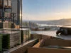 Des jeux Xbox en boîte sur un tapis roulant avec une console et une manette, devant une vue panoramique au coucher.