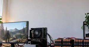 Un PC Ryzen sous Linux alimenté par une rangée de 192 piles AA connectées par des câbles sur un bureau en bois.