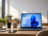Un ordinateur portable ouvert sur un bureau montrant une comparaison entre un écran avec et sans transparence Windows 11.