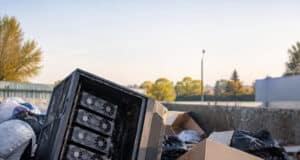 Une tour PC Phanteks jetée dans une benne contenant quatre cartes graphiques GTX 1080 Ti alignées verticalement.