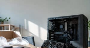 Une carte graphique RTX 3090 est posée devant un boîtier PC ouvert sur une table avec du matériel d'emballage.