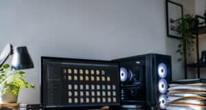 Bureau avec PC gaming et écran affichant des dossiers, illustrant un manque d'espace de stockage.