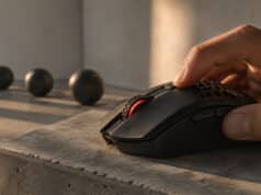 Comment régler le dpi de sa souris gaming pour progresser Une main utilise une souris gaming noire avec un éclairage rouge sur un socle en béton sous une lumière naturelle.