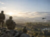 Squad, FPS tactique gratuit sur PS5, face à Call of Duty Trois soldats en tenue tactique observent une vallée montagneuse au coucher du soleil avec un hélicoptère au loin.