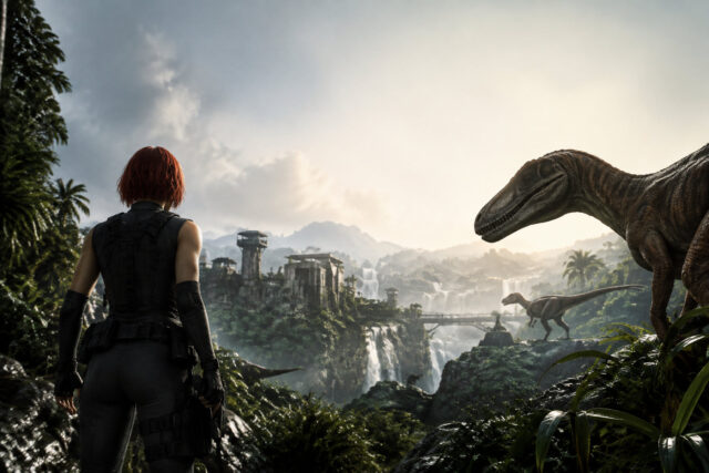 Dino Crisis 2 : Retour dans la jungle jurassique Une femme aux cheveux roux regarde des dinosaures dans une jungle tropicale luxuriante avec des ruines en arrière-plan.