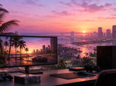 Comment installer des mods sur GTA 6 Un setup gaming avec un écran affichant un jeu de style GTA 6 devant une vue réelle sur une ville au coucher du soleil.