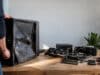 Un PC gamer acheté 20 € aux enchères, une vraie aubaine Un homme inspecte un boîtier PC gamer gravement endommagé avec des composants démontés sur une table en bois.