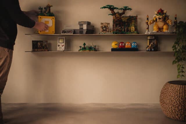 Exposer ses sets LEGO Gaming avec style Une personne ajuste des sets LEGO sur des étagères murales épurées, avec des modèles inspirés de jeux vidéo emblématiques.