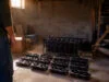 Un joueur trouve 12 RTX 3070 issues du minage dans sa cave Un homme observe 12 cartes graphiques RTX 3070 posées sur le sol d'une cave sombre à côté d'un rack de minage.