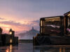 Boutique Valorant : comprendre la rotation des skins Présentoir de skins d'armes Valorant au coucher du soleil avec une cité mystérieuse en arrière-plan.
