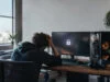 Un étudiant américain et son PC gamer verrouillé à distance Un étudiant assis à son bureau, la tête dans les mains, face à un écran de PC gamer affichant une icône de cadenas.