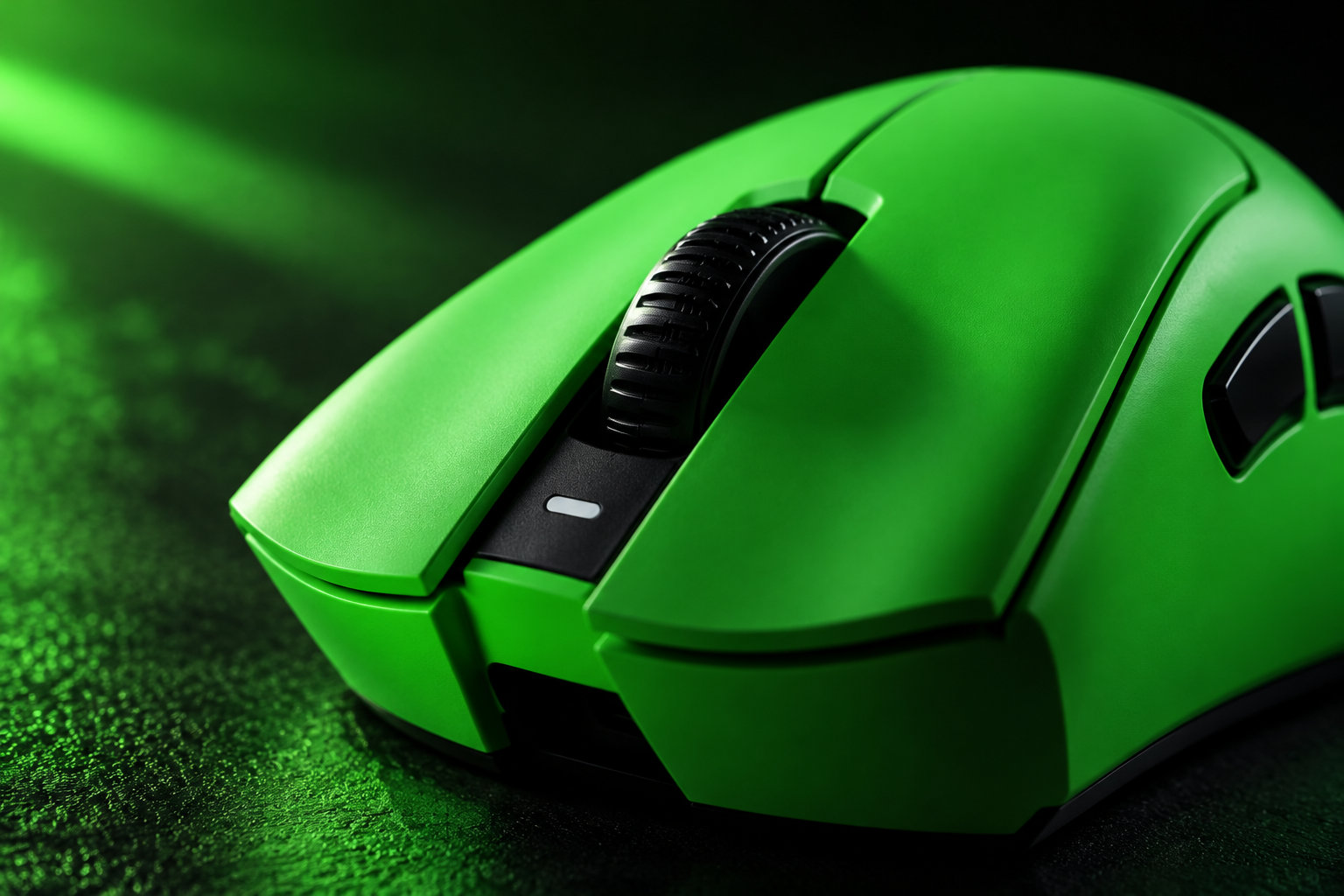 Une souris d’ordinateur verte est photographiée en gros plan sur une surface sombre, avec une molette noire.